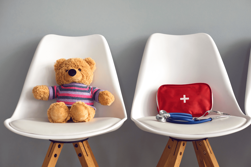 Sala d'attesa pediatrica con peluche e strumenti sanitari, simbolo dell'accoglienza del bambino negli spazi di cura